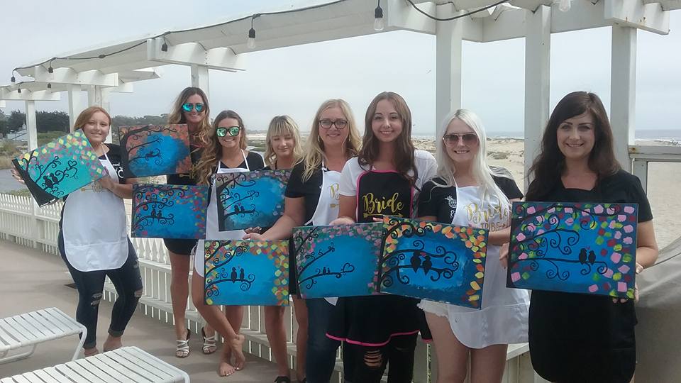 Group smiling and holding their finished paintings